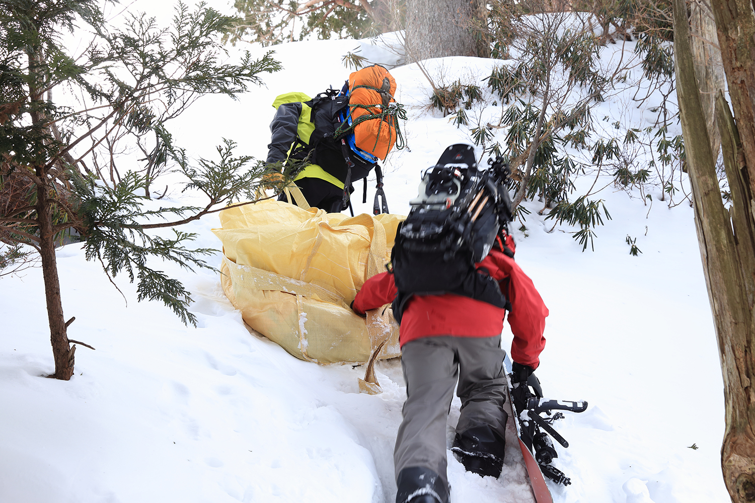 Downhill in the evening.Two people work together to lift a steep slope