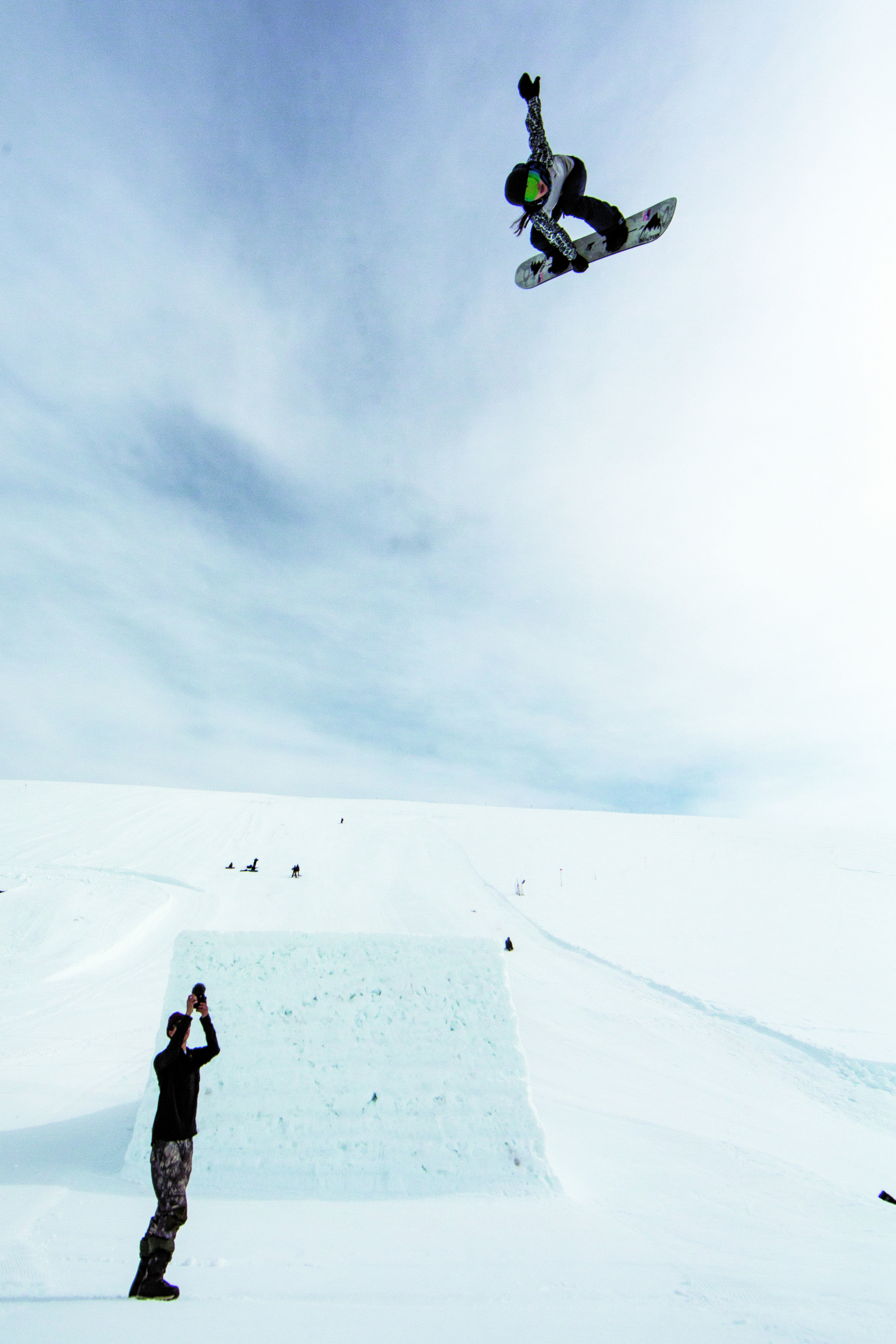 一股充满自信和乐趣的气息从唇边猛地跳了出来。在与比赛不同的跳跃训练环境中，展现自己的滑雪板运动地点：加拿大，AB，阳光村村落景观照片：Erin Hogue
